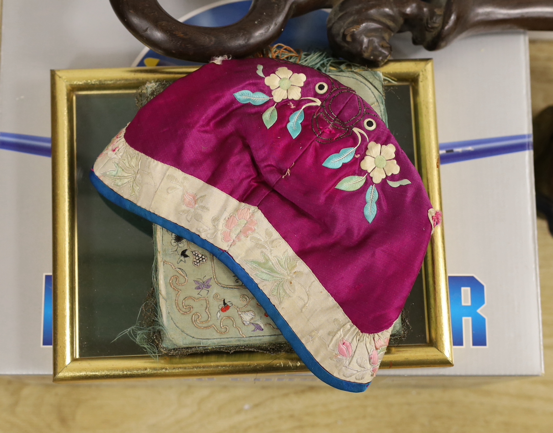 Six items, including an embroidered cap, embroidered box, framed gilt finals, a carved walking stick, a money box, and a diecast military aircraft